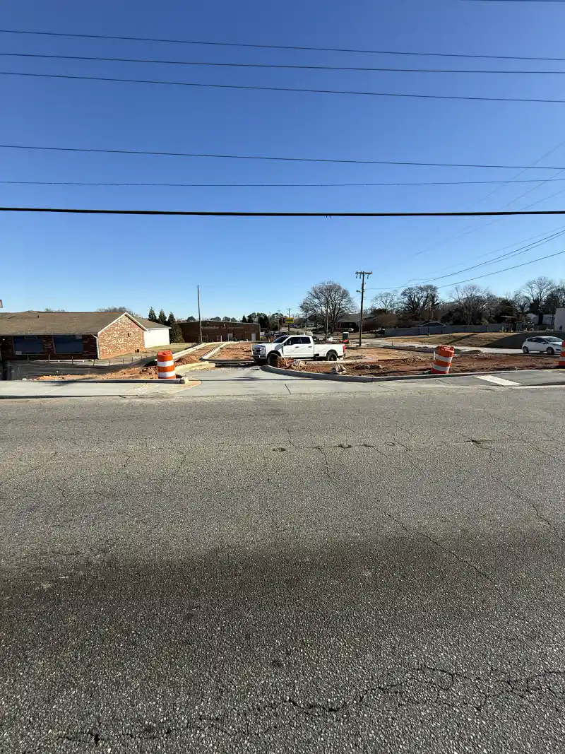 A poured concrete sidewalk running alongside a commercial building.