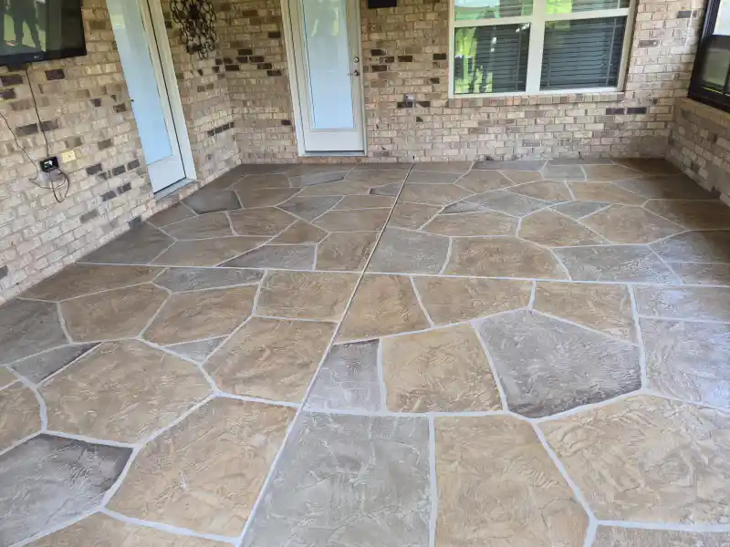 A screened porch floor finished with a grey herringbone brick-pattern overlay, viewed through an open screen door.