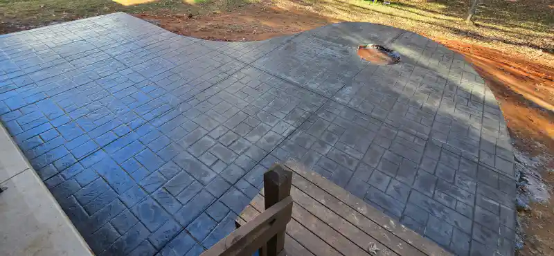 A stamped concrete patio adjoining a house wall.