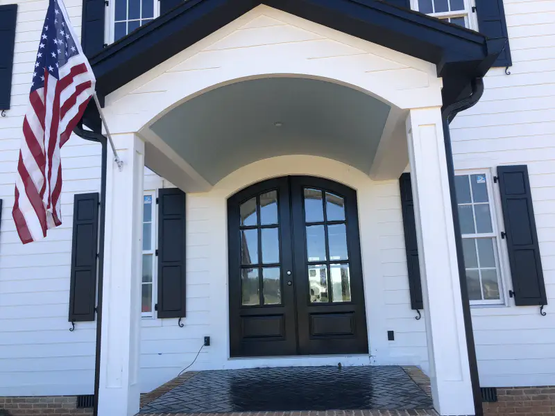 The front entrance of a house, with a stamped concrete surface at the door threshold.