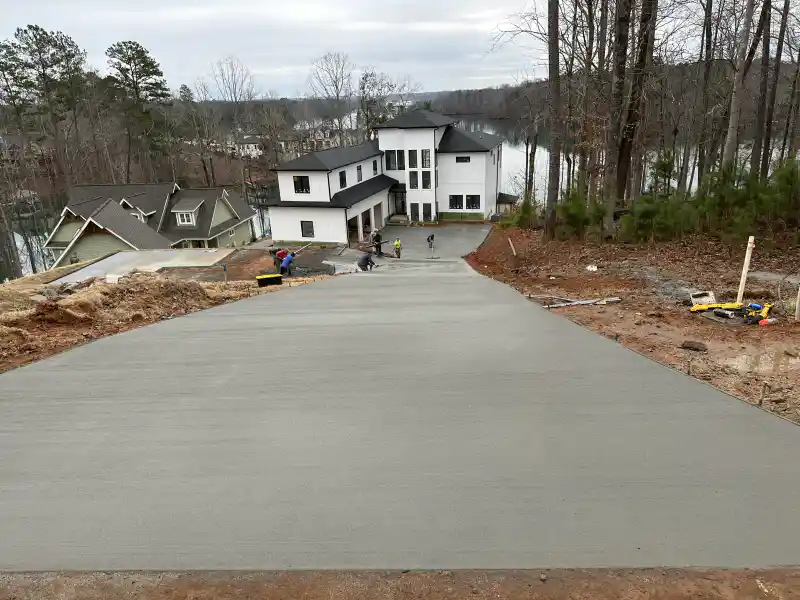 A newly poured concrete driveway replacing an older cracked slab at the same property.