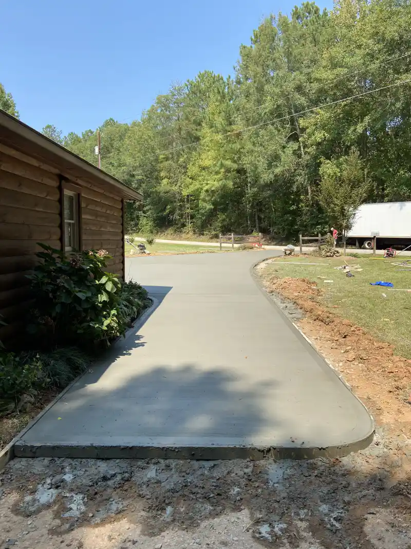 A concrete driveway with a formed edge running over prepared subgrade.
