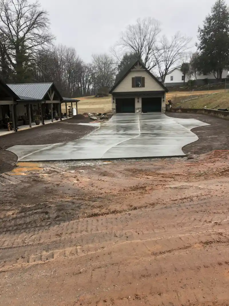 A concrete driveway meeting a garage apron at a residential property.