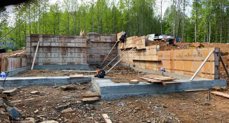 Foundation walls set up in steel-framed forming panels ahead of a concrete pour.