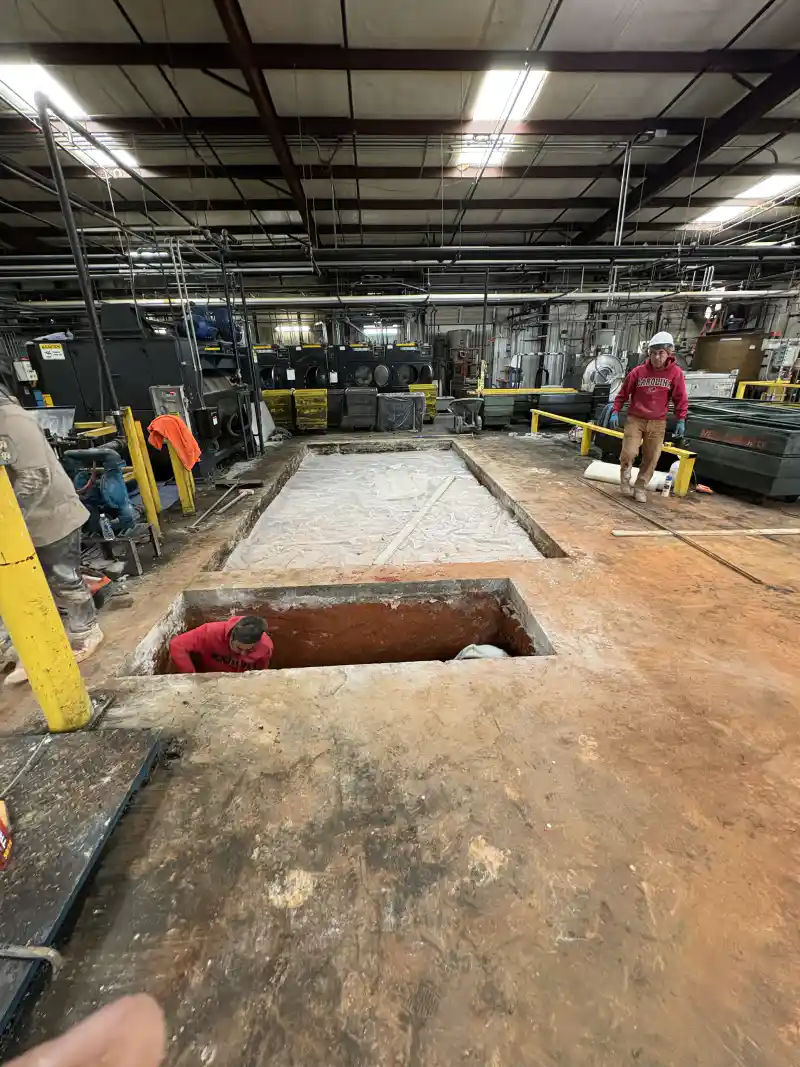 Concrete work around an equipment foundation inside an operating industrial plant.
