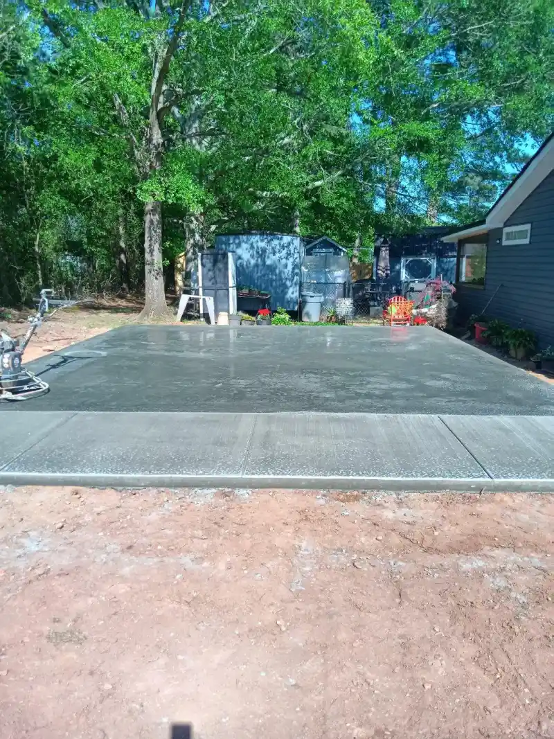 A concrete patio slab laid against the rear wall of a house.