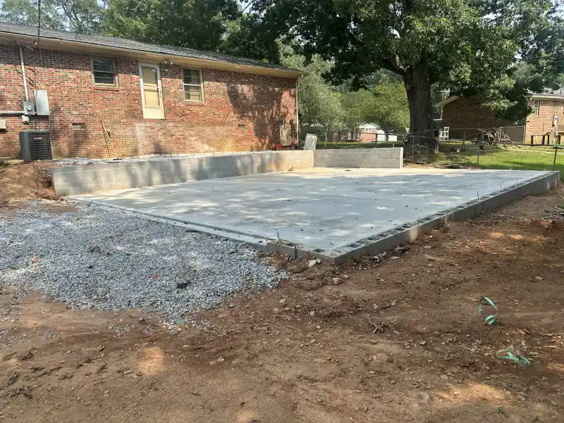 A finished concrete patio slab meeting a mown lawn.