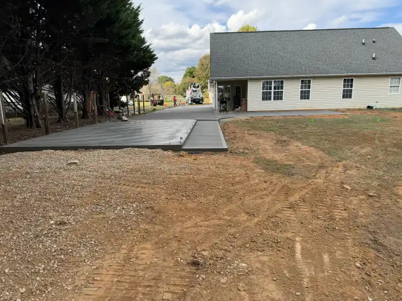 A jointed concrete patio behind a residential house.