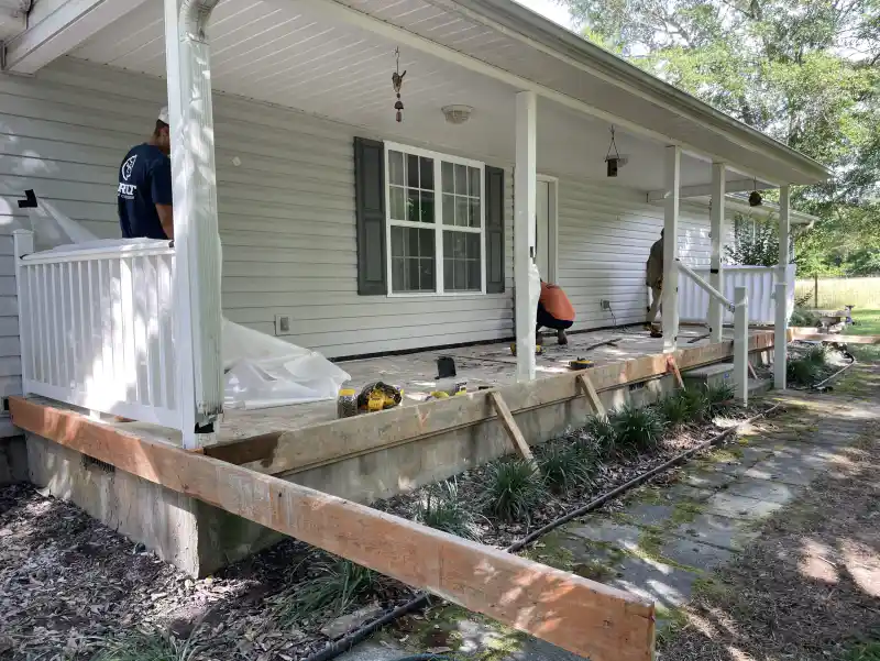 Workers finishing the surface of a concrete front porch slab.