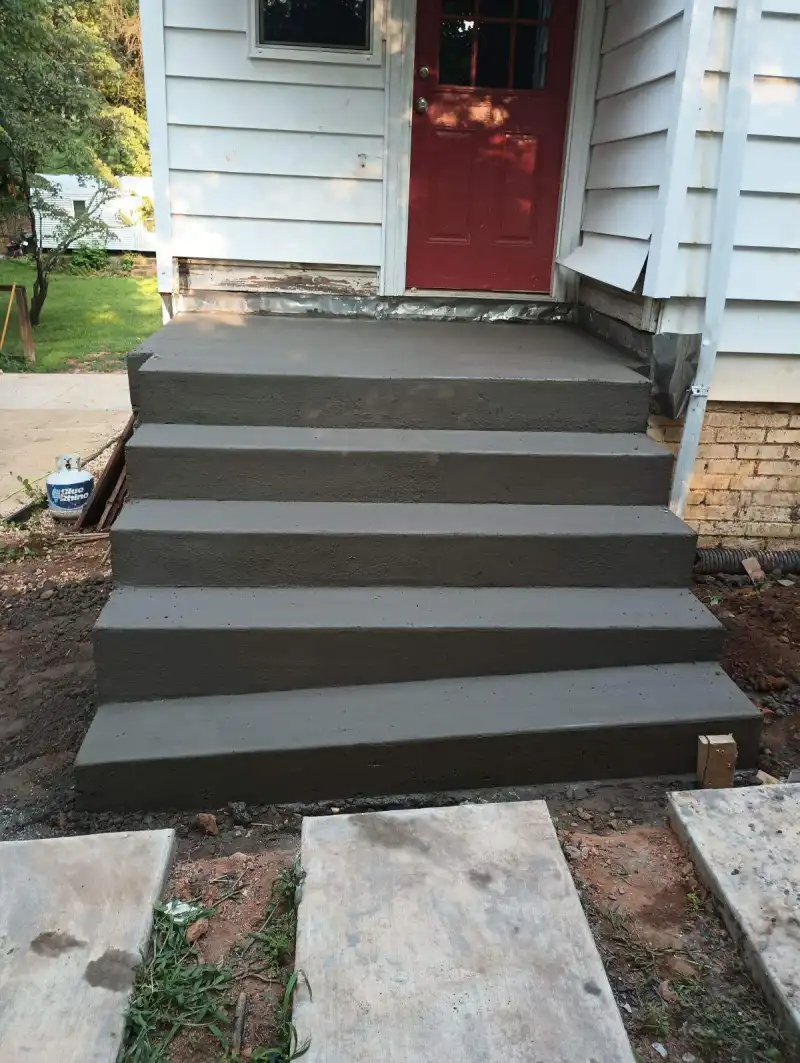 Newly formed concrete steps and landing at a house entrance.