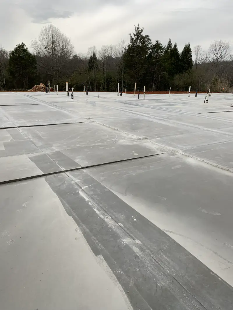 Steel reinforcing bar laid out in a grid over prepared subgrade ahead of a pour.